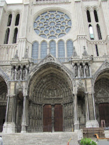 South facade of Chartres cathedral showing entrance (deeply recessed, with stone carvings) and the rose window above it