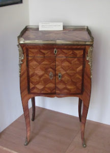 Small writing table with a drawer and a small cupboard beneath the writing surface; the front of the desk features lovely marquetry.