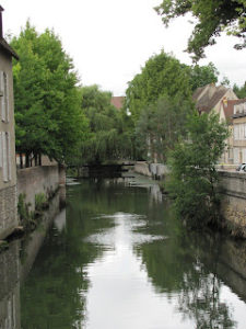 View of Eure River, with buildings and trees on its banks