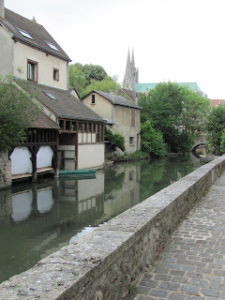 Eure River, with buildings along the left bank and the towers of Chartres cathedral visible in the background