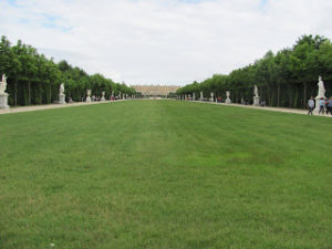 It truly is a very long lawn. The palace is very small in the background. The lawn is bounded by rows of manicured trees, and statues appear at tasteful intervals along paths down the sides of the lawn.